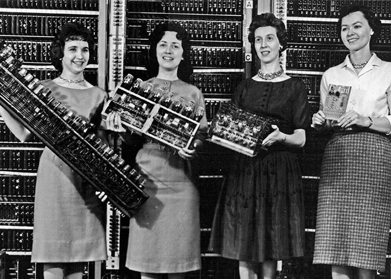 U.S. Army Photo No. 163-12-62. Ltr: Patsy Simmers (mathematician/programmer), holding ENIAC board; Mrs. Gail Taylor, holding EDVAC board; Mrs. Milly Beck, holding ORDVAC board; Mrs. Norma Stec (mathematician/programmer), holding BRLESC-I board.
