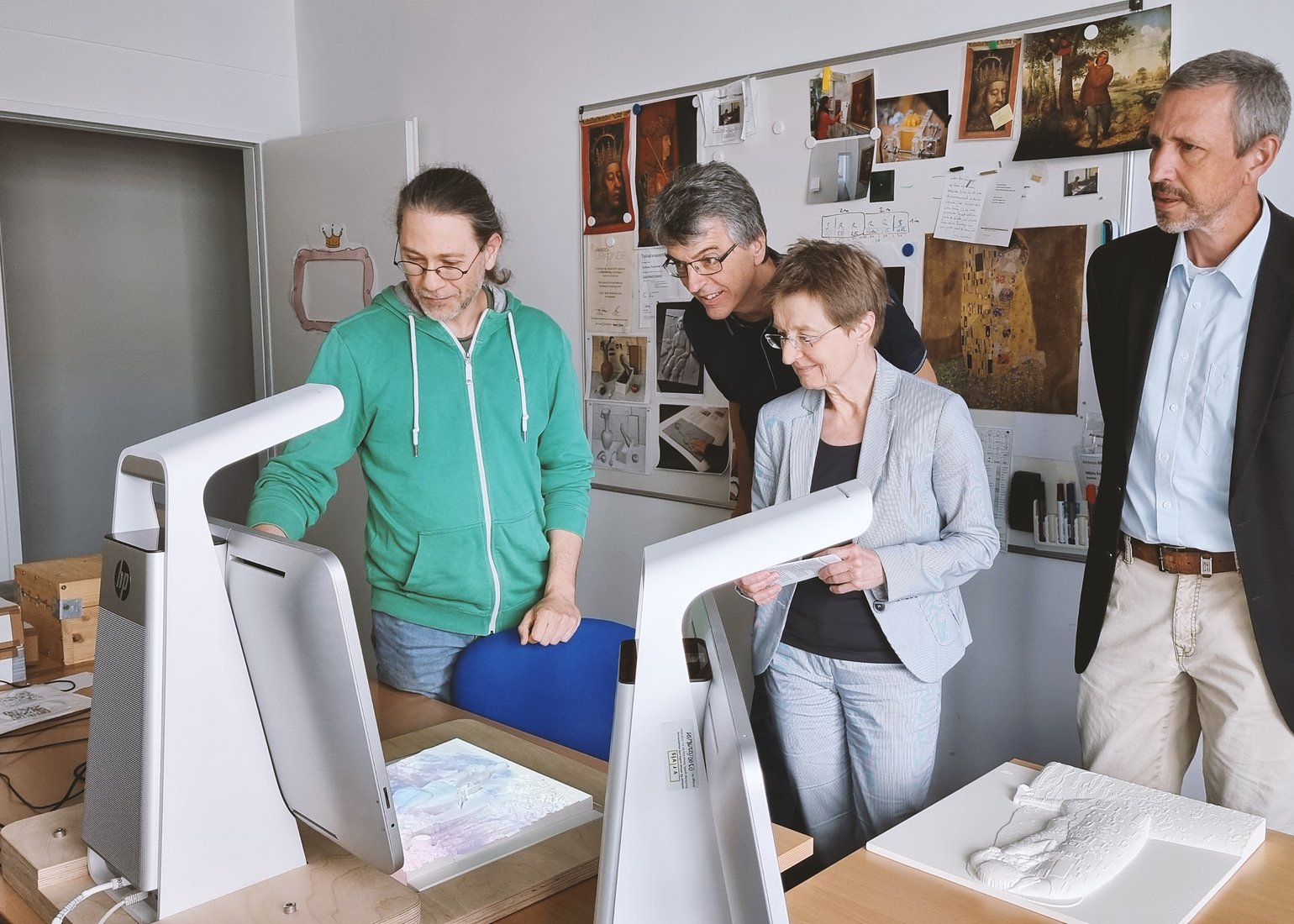 Andi Reichinger (l) presents tactile art for blind people to Peter Puschner, Gerti Kappel and Wolfgang Kastner (ltr).