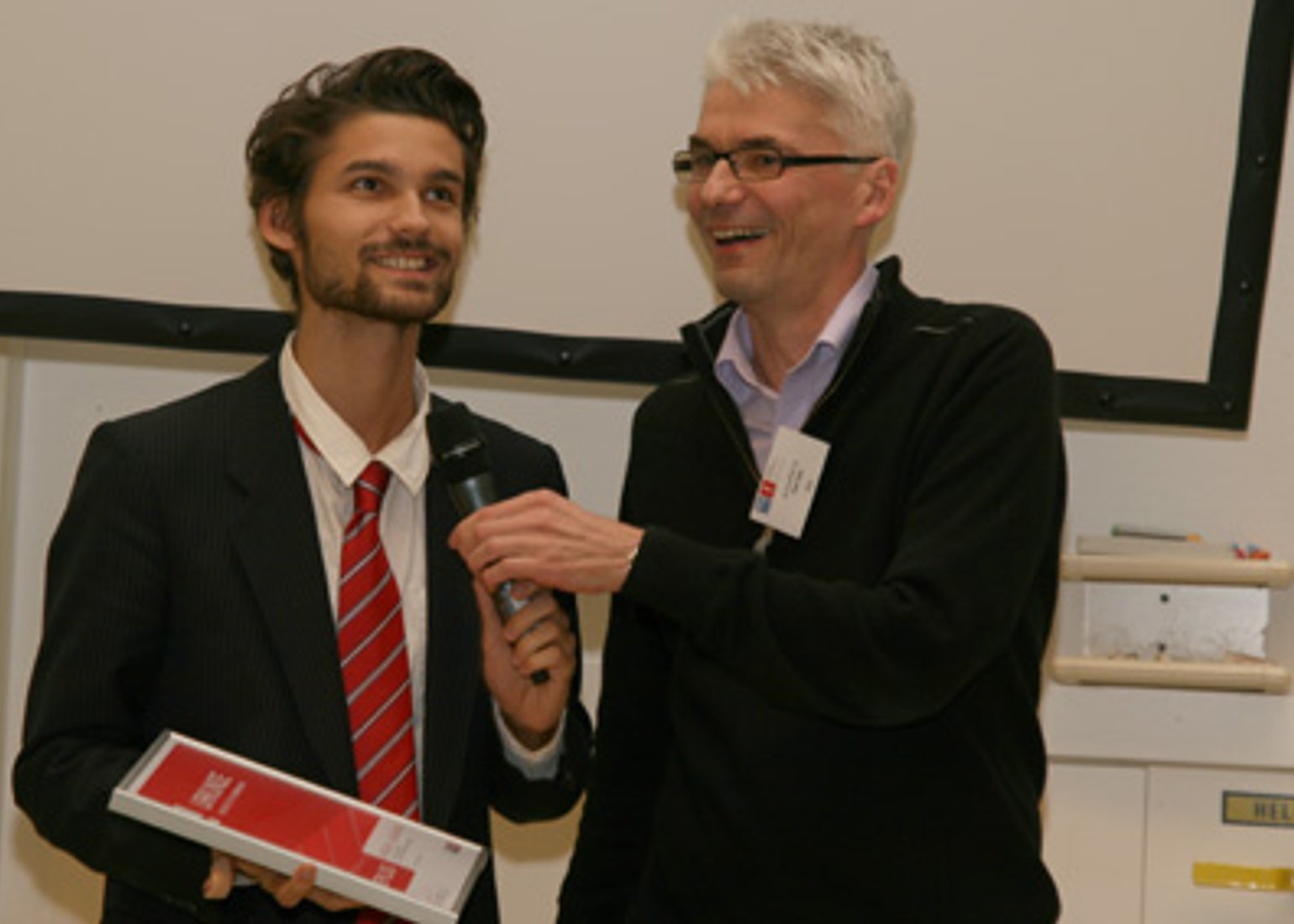 Jury-Vorsitz U. Egly überreicht A. Grünauer den "Best Poster"-Award.