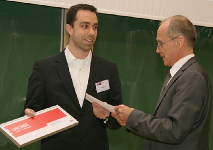 Dekan G. Steinhardt überreicht dem Gewinner des "Distinguished Young Alumnus"-Award G. Seitz die Urkunde und das Preisgeld.