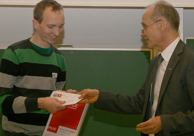 Dekan G. Steinhardt überreicht M. Schwengerer, dem Gewinner des Best Poster Award der Fakultät, das Preisgeld. — Picture: TU Wien Informatics